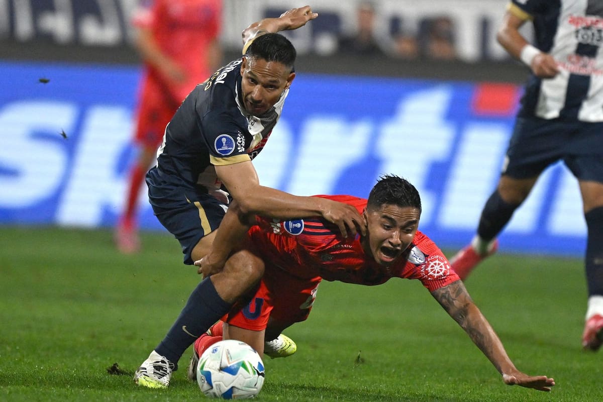 Alianza Lima's defender #06 Renzo Garces (L) and Universidad de Chile's forward #11 Nicolas Guerra (R) fight for the ball during the Copa Sudamericana quarterfinal first leg football match between Peru's Alianza Lima and Chile's Universidad de Chile at the Alejandro Villanueva Stadium in Lima on September 18, 2025. (Photo by Ernesto BENAVIDES / AFP)