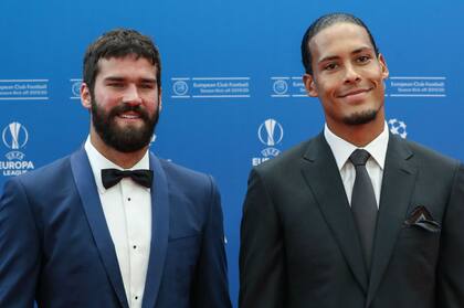 Alisson Becker, de moño negro, y el defensor Virgil van Dijk, en el arribo a la gala