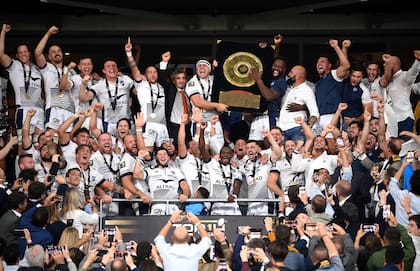 Altrad celebra al lado del capitán, Guilhem Guirado, y el resto del plantel con el peculiar trofeo Bouclier de Brennus; el propietario de Montpellier comparte tiempo con el plantel y se involucra continuamente con el equipo.
