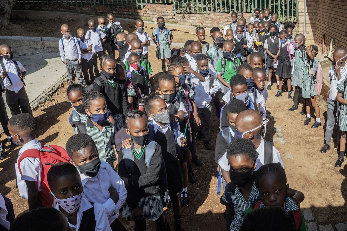 Alumnos de Ithute Higher Primary School hacen cola durante el primer día del nuevo año académico, en Alexandra, Johannesburgo, el 15 de febrero de 2021