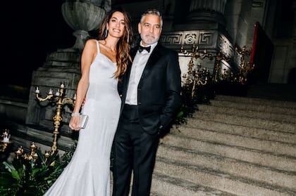 Amal optó por un diseño de inspiración nupcial que lleva la firma de Donatella Versace. Se trata de un impresionante vestido blanco cubierto de cristales, con finos breteles y larga cola. Lo acompañó con un clutch a juego con su outfit y cierre-joya.