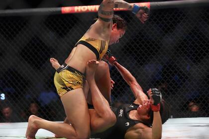 Amanda Nunes castiga a Julianna Peña en el combate por el título de peso gallo de artes marciales mixtas, el sábado 30 de julio de 2022, en Dallas. (AP Foto/Richard W. Rodríguez)