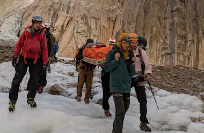 Amanecer del domingo en el cerro Torre, mientras los rescatistas descienden la camilla con una de las accidentadas