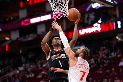 Amen Thompson (1), de los Rockets de Houston, se alza para encestar mientras Amir Coffey (7), de los Clippers de Los Ángeles, defiende durante la primera mitad del juego de baloncesto de la NBA, el miércoles 13 de noviembre de 2024, en Houston. (AP Foto/David J. Phillip)