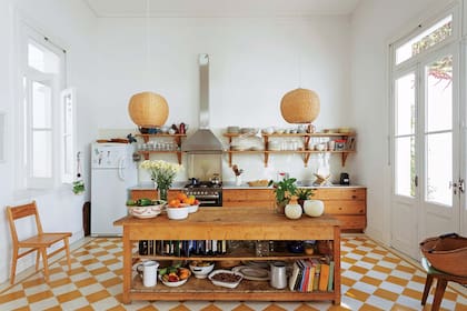 Amoblamiento de cocina en pino tea recuperada, mesada de mármol de Carrara (El Progreso Marmolería Mecánica), artefacto de 6 hornallas (Whirlpool), campana industrial (Teknoventilación) y mesón de madera (Rajatabla).