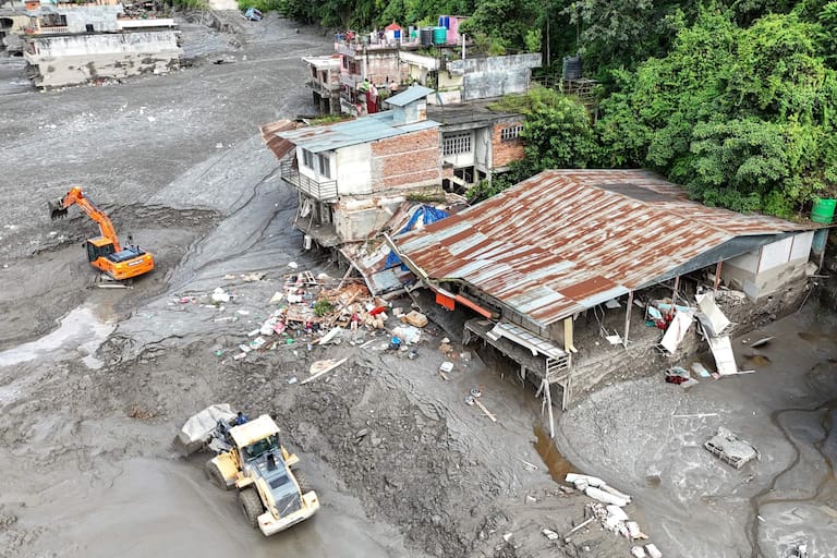 An aerial view shows workers using excavators to clear sludge following flash floods at Trishuli in Nepal's Nuwakot district on August 27, 2026. Rescue teams scoured devastated zones August 27 for more than 1,300 people missing a day after flash floods and landslides along the Nepal-Tibet border killed at least 273, sweeping away entire villages. (Photo by Arun SANKAR / AFP)