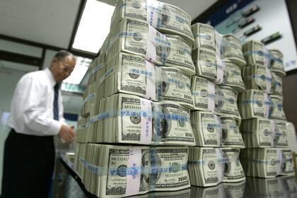 An employee of the Korea Exchange Bank (KEB) counts 100-dollar bills for foreign bonds redemption at the banks headquarters in Seoul October 9, 2008. South Koreas foreign exchange authorities were seen selling dollars to help the won