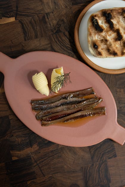 Anchoas artesanales conservadas en aceite de oliva, pan casero terminado a la brasa y manteca Lobos
