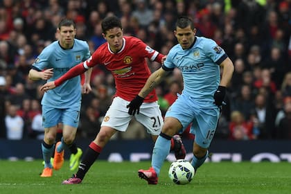 Ander Herrera, con la camiseta de Manchester United, persigue al Kun Agüero, en el clásico de la ciudad