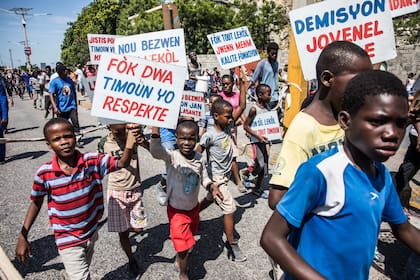 "Los derechos de los niños deben ser respetados", dice el cartel de un niño haitiano durante la protestas que exigen la dimisión del presidente Jovenel Moïse