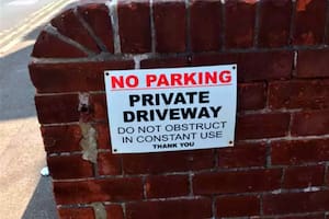 "Prohibido estacionar. Entrada privada. No obstruya. En constante usoo. Gracias", se puede leer en el letrero de Tobe Bailey