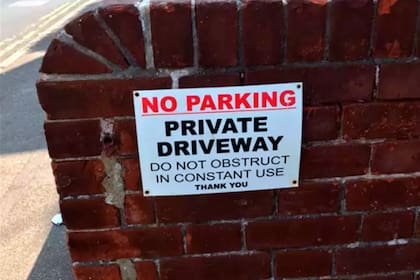 "Prohibido estacionar. Entrada privada. No obstruya. En constante usoo. Gracias", se puede leer en el letrero de Tobe Bailey