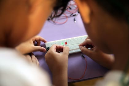 Los chicos trabajando en un proyecto de mecatrónica, comparten roles y colaboran entre ellos.