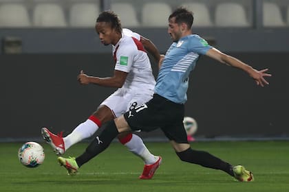 André Carrillo, delantero de Perú, desborda y mete el centro ante la marca de Matías Viña, lateral izquierdo de Uruguay; no se sacaron ventajas en Lima, por las Eliminatorias para Qatar 2022