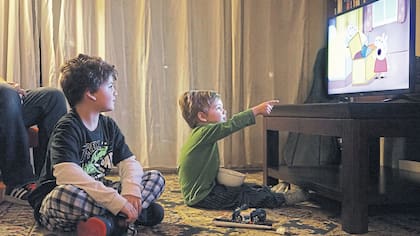 Andrés Milicich, de dos años, ve Peppa Pig acompañado de su papá Maximiliano y de Iván, su hermano mayor