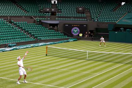 Andy Murray saca frente a Dan Evans en su entrenamiento en el All England Lawn Tennis y Croquet Club, en Wimbledon, Inglaterra, de cara al inicio del torneo, el jueves 29 de junio de 2023. (Steven Paston/PA vía AP)