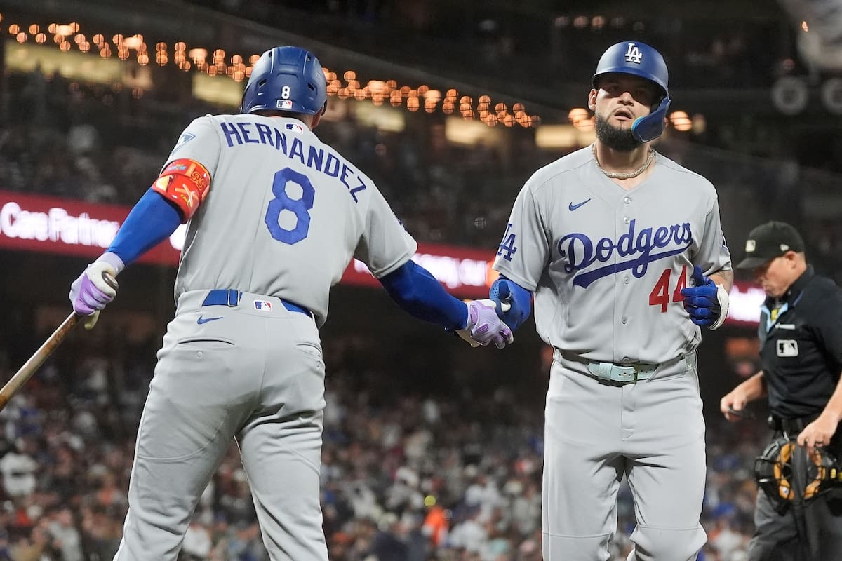 Andy Pagés, derecha, de los Dodgers de Los Ángeles, es felicitado por Enrique Hernández (8) despúes