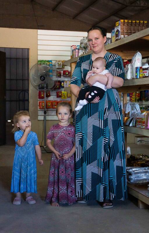 Anganeta, a cargo del almacén de la colonia, junto a sus hijas.