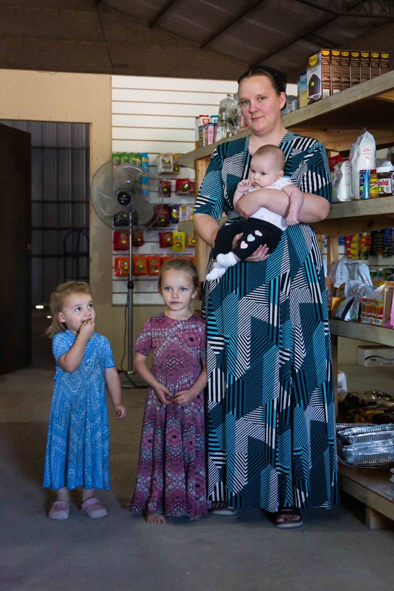 Anganeta, a cargo del almacén de la colonia, junto a sus hijas.