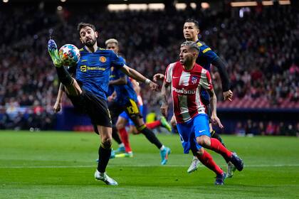 Ángel Correa va a buscar la pelota que intenta controlar Bruno Fernandes
