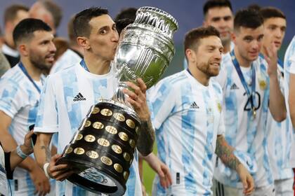 Ángel di María, de la selección de Argentina, besa el trofeo tras la final de la Copa América, un triunfo sobre Argentina en el Maracaná, el sábado 10 de julio de 2021 (AP Foto/Andre Penner)