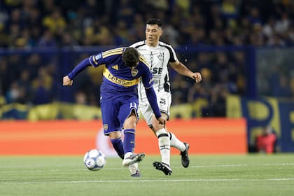 Ángel Romero pasa la pelota ante la mirada de Leonardo Sequeira, amonestado