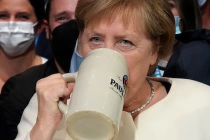 Angela Merkel bebe una cerveza local durante un mitin de campaña en Munich, Alemania