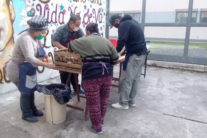 Angélica (de delantal azul) junto a algunas de las voluntarias y voluntarios del comedor El Enano, en la villa 20 de Lugano