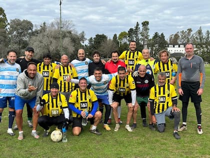 Aníbal, de rojo, entremezclado con el resto de sus amigos en una cancha de fútbol