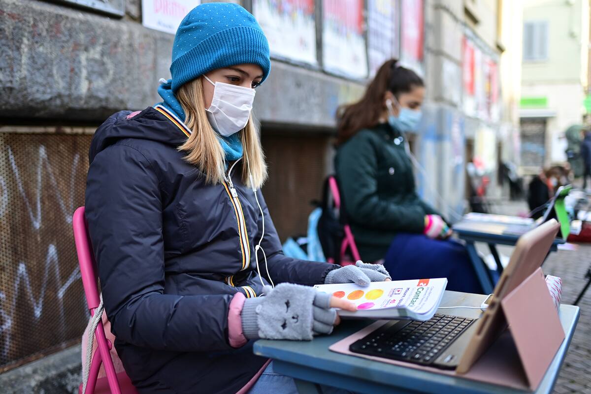 Anita Lacovelli y su amiga Lisa Rogliatti, ambas de 12 años, se sientan frente a la escuela Italo Calvino en Turín mientras protestan contra el cierre de escuelas debido a las restricciones por Covid-19, el 17 de noviembre de 2020
