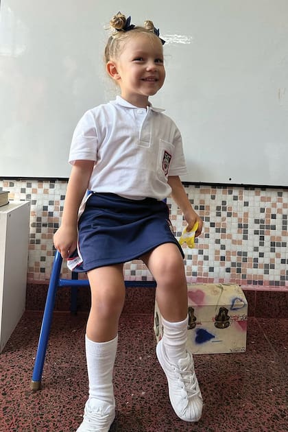 Anita posa en el aula con dos simpáticos rodetes atados con moños
azules y el uniforme del colegio.