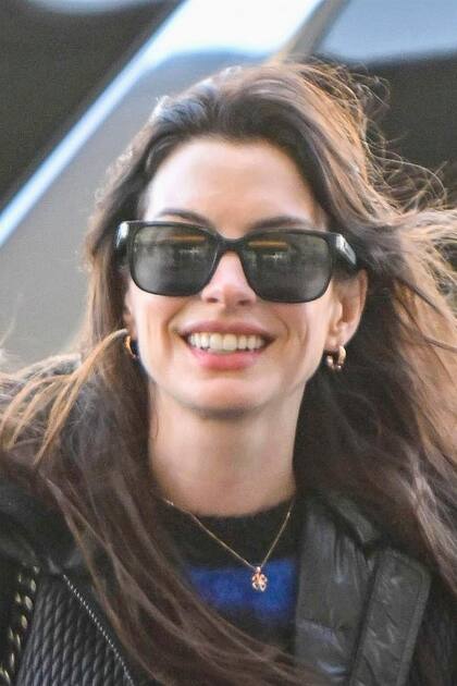 Anne Hathaway fue captada por las cámaras antes de subir a un avión y les regaló a los paparazzi una de sus clásicas sonrisas