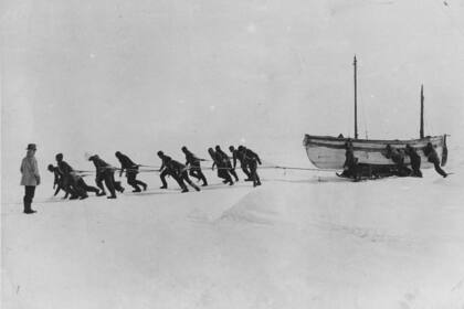 ANTÁRTICA - 1916: Los miembros de un equipo de expedición dirigido por el explorador irlandés Sir Ernest Henry Shackleton tiran de uno de sus botes salvavidas a través de la nieve en la Antártida, tras la pérdida del 'Endurance'. (Foto de Hulton Archive/Getty Images)