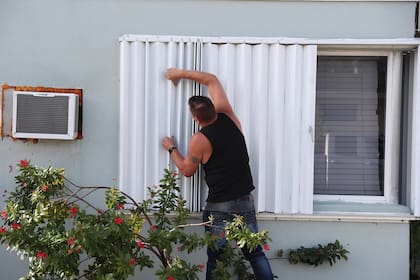 Anthony Perrone cierra las persianas de huracán en su casa el 31 de julio de 2020 en Lake Worth, Florida. Perrone dijo que cerró las persianas para preparar su hogar para la posible llegada del huracán Isaias. Se espera que el huracán golpee la costa este de Florida