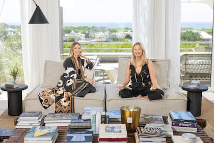 Anushka y Sol, en uno de los ambientes de la casa preferidos por toda la familia. Detrás, una vista increíble del mar y del faro de José Ignacio. En la mesa, libros de decoración y fotografía –elegidos por Sol y Natasha-, de moda –seleccionados por Anushka– y de cocina –escogidos por Chicho, el marido de Sol–.