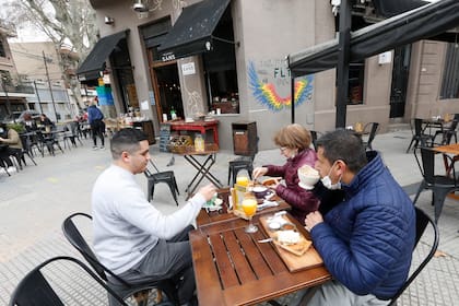 Apertura de bares y restaurantes con mesas y sillas en la vereda en CABA