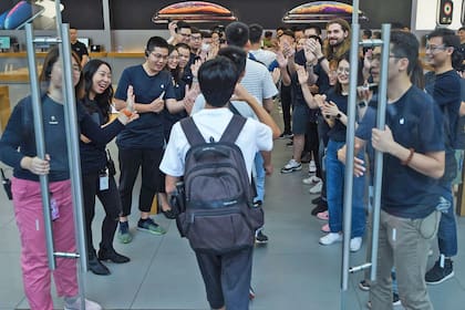 Con aplausos los vendedores reciben a los primeros compradores de la tienda en China