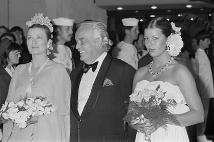 Aprendió de su madre, Grace Kelly, a “coronarse” con flores o sumarlas una a un costado de su peinado, una forma de quitarles algo de seriedad a los looks más exigentes. En la imagen de 1975 se ve a Carolina con sus padres, en su debut en el tradicional Baile de la Rosa.