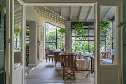 Aprovecharon todos los rincones del jardín de invierno: armaron un espacio de trabajo con escritorio y silla, y un sector de estar.