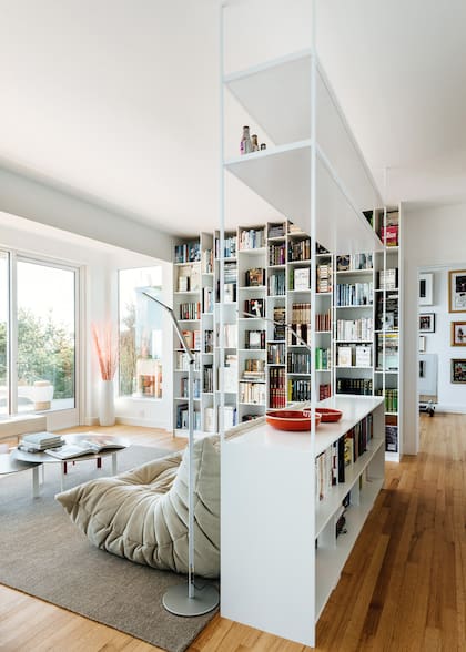 Aquí, la colección de libros se aloja en estanterías del suelo al techo, con compartimentos asimétricos para objetos de diferentes tamaños.