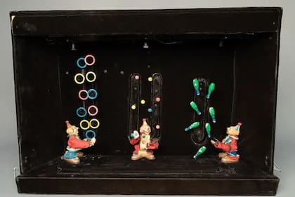 Aquí ves evidencia de dos de sus pasiones: hacer artilugios y malabarismo: 3 payasos parecen hacer malabarismos con mazas, pelotas y aros; detrás del diorama, una compleja maquinaria mantiene todo en movimiento, y un instrumento Casio VL-Tone reproduce música
