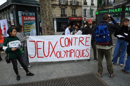ARCHIVO - Activistas opuestos a las Olimpiadas de París despliegan una manta que dice: "Contra los Juegos Olímpicos"
