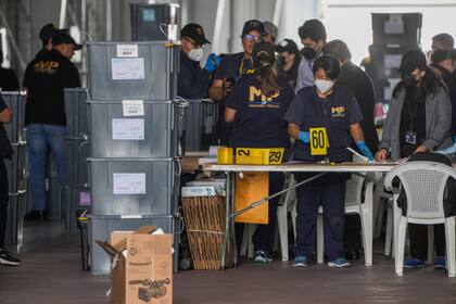 ARCHIVO - Agentes de la Fiscalía General revisan actas electorales de los comicios del 25 de junio en un allanamiento a la sede del Tribunal Supremo Electoral, en Ciudad de Guatemala, el 12 de septiembre de 2023. (AP Foto/Moisés Castillo, Archivo)