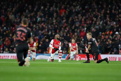 ARCHIVO - Alexandre Lacazette (centro) de Arsenal se arrodilla previo al partido contra Southampton en la Liga Premier, el 11 de diciembre de 2021. (AP Foto/Ian Walton)