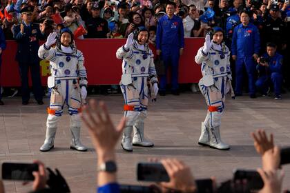 ARCHIVO - Astronautas chinos de la misión Shenzhou-18, de derecha a izquierda Ye Guangfu, Li Cong y Li Guangsu, saludan en una ceremonia de despedida para su misión tripulada en el centro de lanzamiento de satélites Jiuquan en el noroeste de China, el 25 de abril de 2024. (AP Foto/Andy Wong, Archivo)