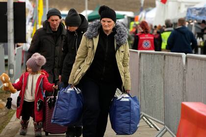 Archivo - Centenares de refugiados, mayormente mujeres y niños, aguardan para ser transportados después de huir de Ucrania, cruzar la frontera y llegar a Medyka, Polonia, el 7 de marzo de 2022. (AP Foto/Markus Schreiber, Archivo)