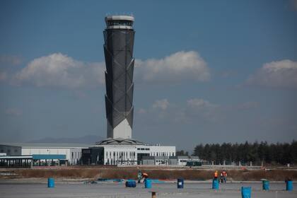 ARCHIVO - Con la torre de control de tráfico aéreo como telón de fondo, varios obreros trabajan en el Aeropuerto Internacional Felipe Ángeles, el 31 de enero de 2022, en las afueras de Ciudad de México. (AP Foto/Ginnette Riquelme, Archivo)