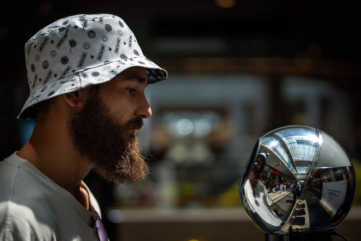 ARCHIVO - Daniel Kertusha, de 21 años, se coloca frente a un orbe para que le escanee los globos oculares en un punto de registro de Worldcoin en Barcelona, el viernes 4 de agosto de 2023. (AP Foto/Emilio Morenatti, Archivo)