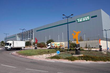 ARCHIVO - Dos camiones circulan frente al centro logístico de Teva Pharmaceuticals, el 16 de octubre de 2013, en la ciudad de Shoam, Israel. (AP Foto/Dan Balilty, archivo)