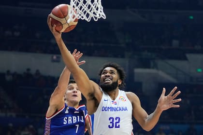 ARCHIVO - El alero dominicano Karl-Anthony Towns busca encestar delante del base serbio Bogdan Bogdanovic, durante un partido del Mundial en Manila, el domingo 3 de septiembre de 2023 (AP Foto/Aaron Favila, archivo)